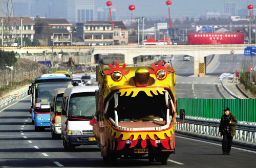 图为在一辆五彩缤纷的"龙车"开道下,载有建设